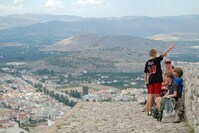 Ausblick Nafplion Eine Familie, die an einem Aussichtspunkt sitzt und auf Nafplion schaut