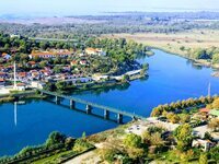 Knall blauer Fluss umgeben von der Landschaft Albaniens und einer Brücke, welche über die Mitte des Flusses verläuft