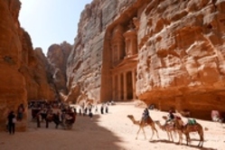 Ein Weg zwischen den Felsen in Petra, wo Menschen und Kamele stehen