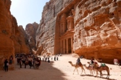 Eine Gruppe von Leuten mit Kamelen in der Wüste in Petra
