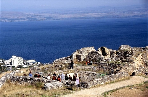 Tiberias Eine Gruppe von Leuten schaut sich eine Ausgrabung in Tiberias an und im Hintergrund sieht man das Meer